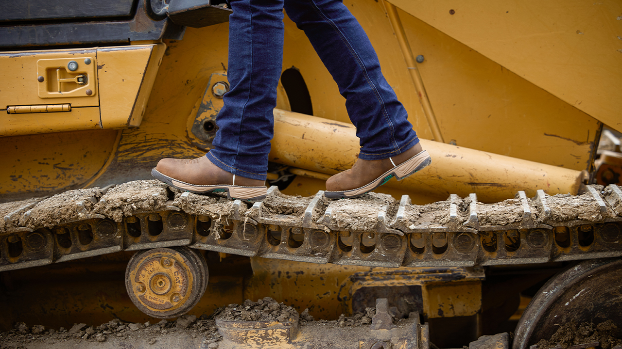 A person walking on a construction truck treads wearing a pair of Rush boots in Pine Chocolate.